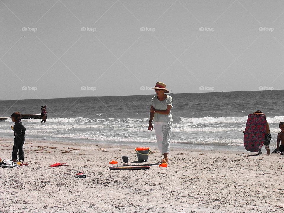 Woman on Florida beach. Woman in white with hat walking on Florida beach