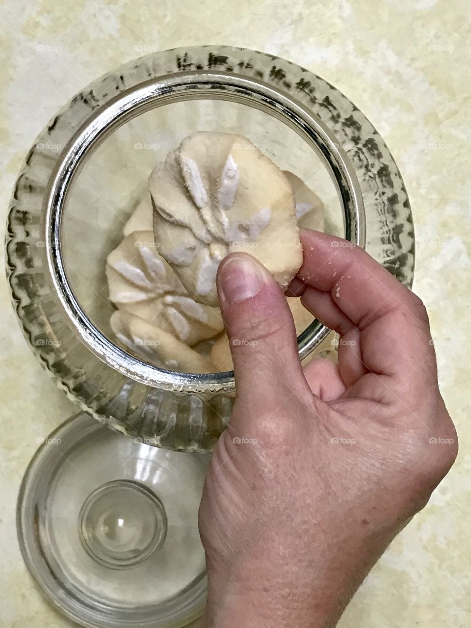 Hand taking cookie out of a cookie jar