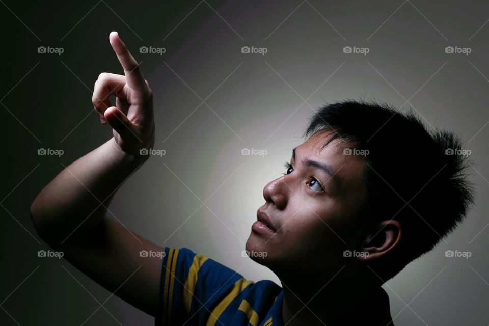 male teenager looking up pointing up