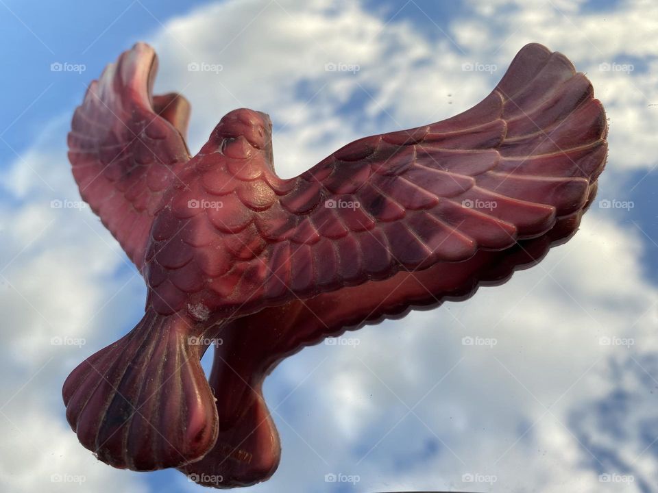 A model for a flying bird made from plastic looks like it is flying in the sky 
