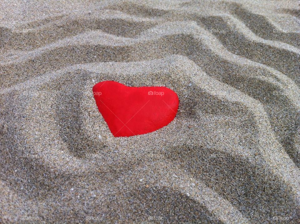 Red heart in the sand