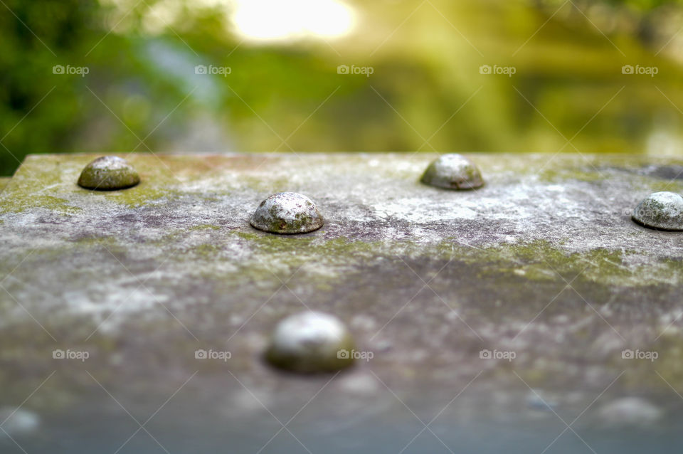 Close-up of metal rivets on a metal beam outdoors