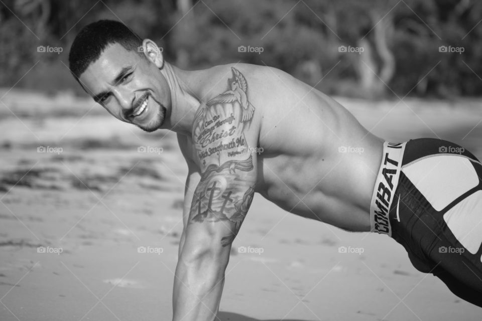 Muscular man exercising at beach