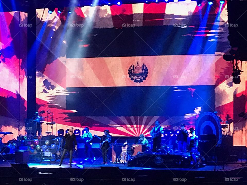 Spanish concert/festival in California with music, singing, dancing, singing, eating and drinking with fun family and friends with El Salvador Flag in background