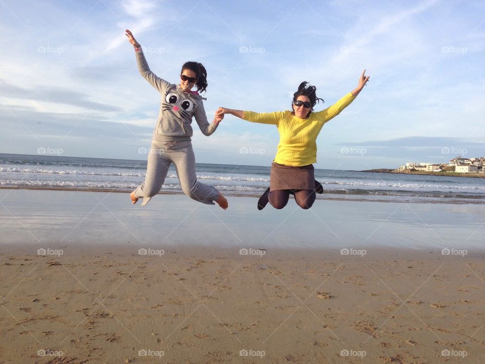 Girls jumping high on the beach