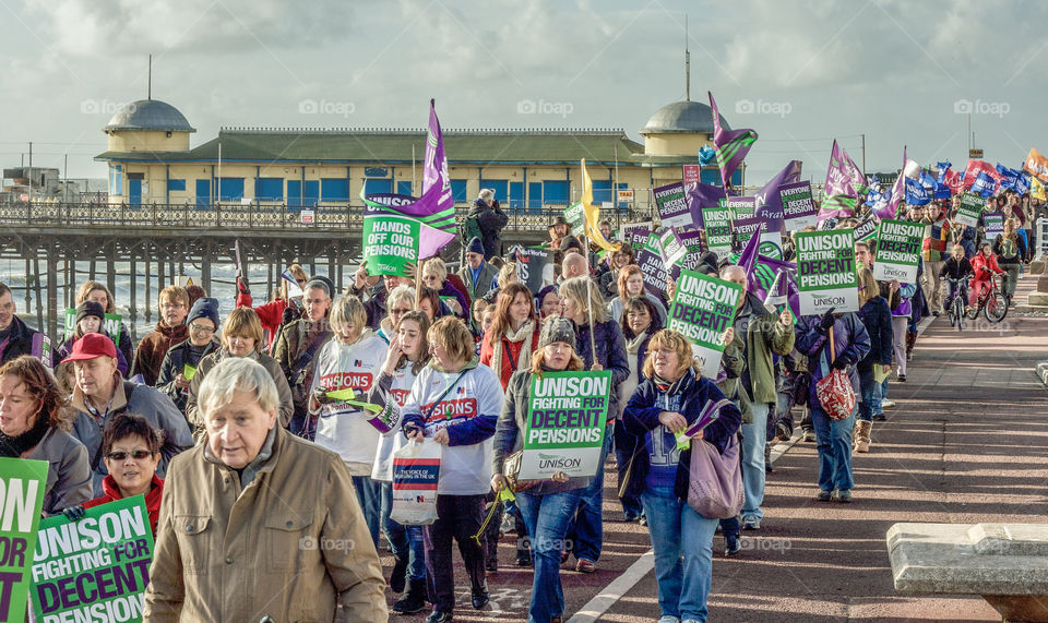 Protesters march along past Hastings pier to demonstrate against government cuts - November 2011