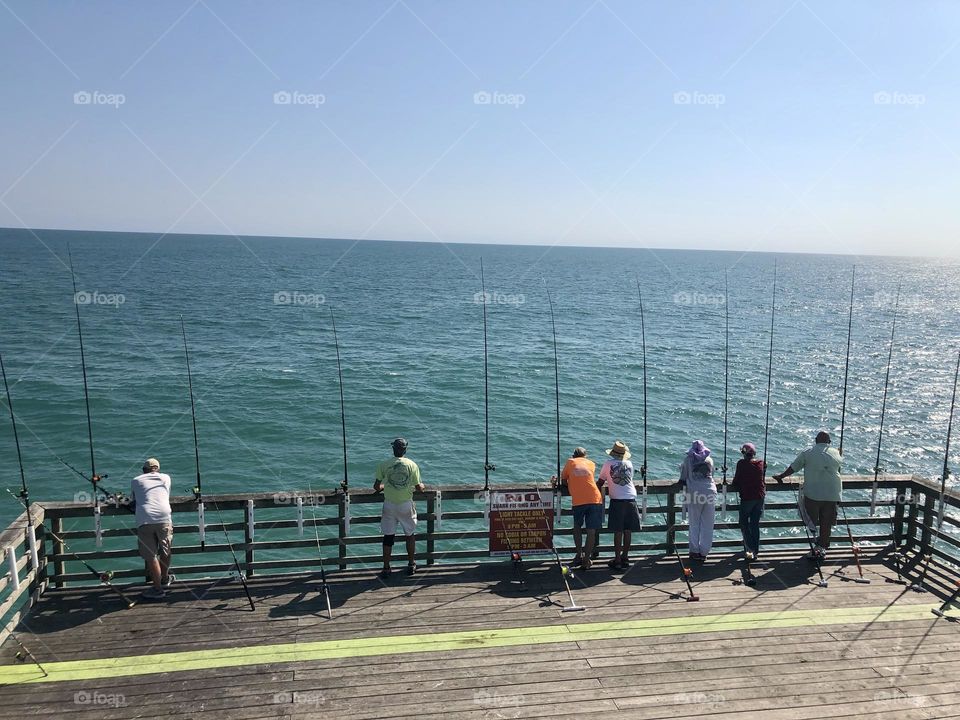 Fishermen fishing off of the North Carolina Peer at Emerald Isles waiting for the perfect catch.