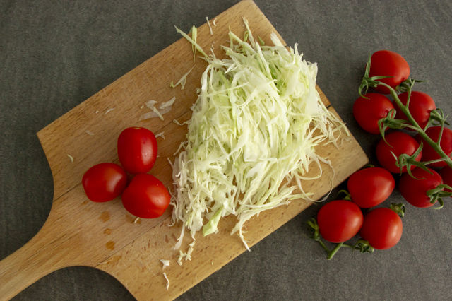 Flat lay - preparing tomatoes and cabbage  salad with onion