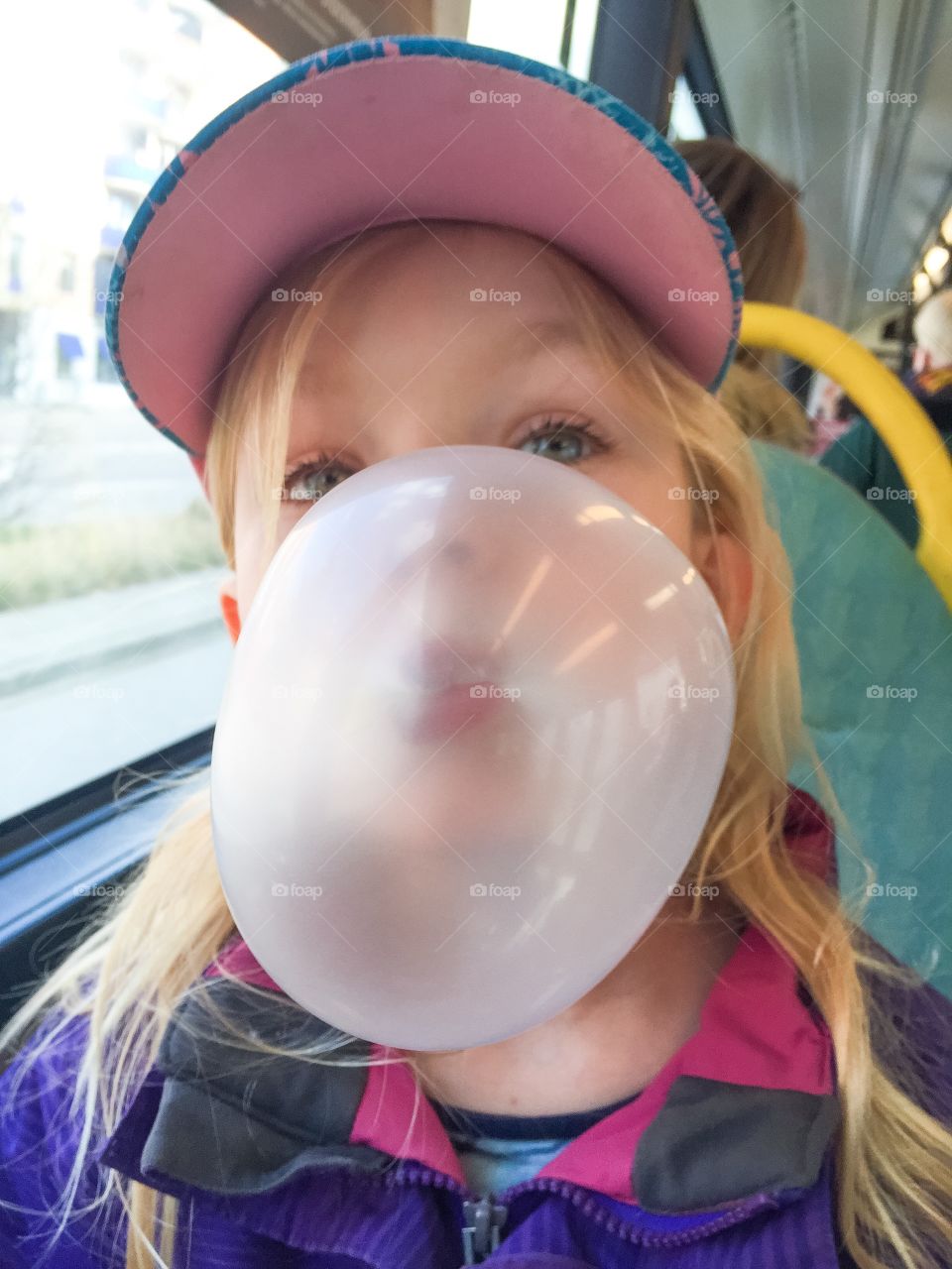 Young girl of five blowing bubble gum.