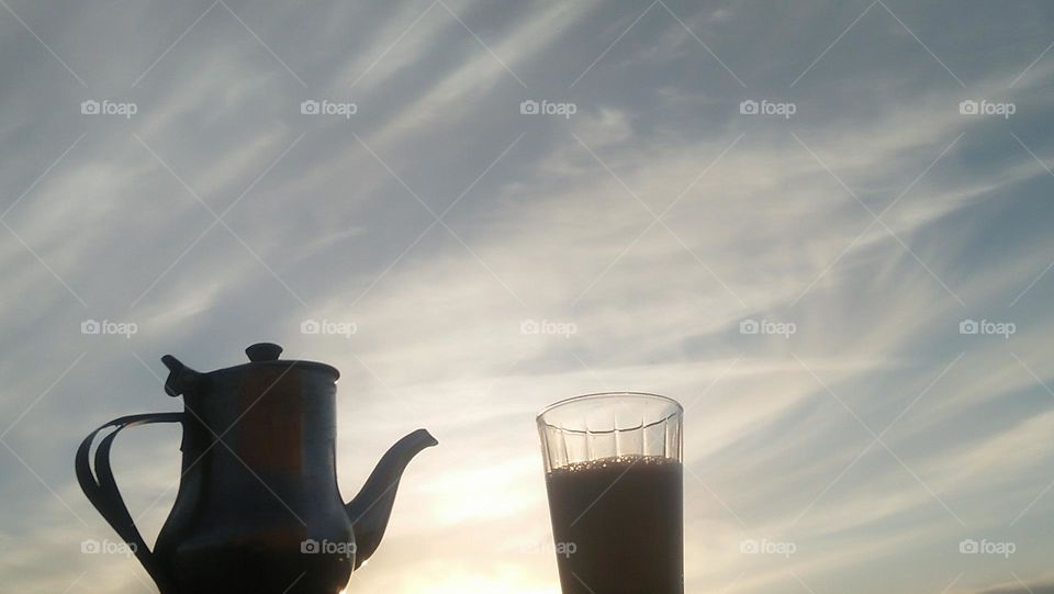 A jug and a glass hugging the glamour of sunset.