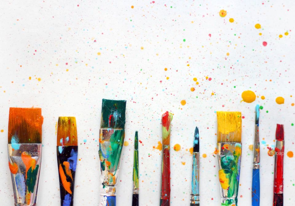 Colorful paintbrushes and paint in a row
