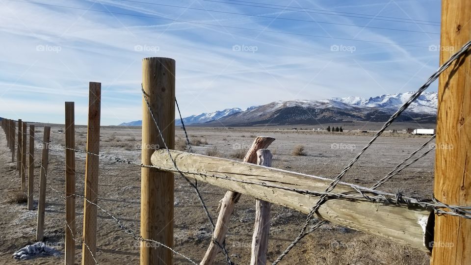 Fence with view of snow capped mountains in background