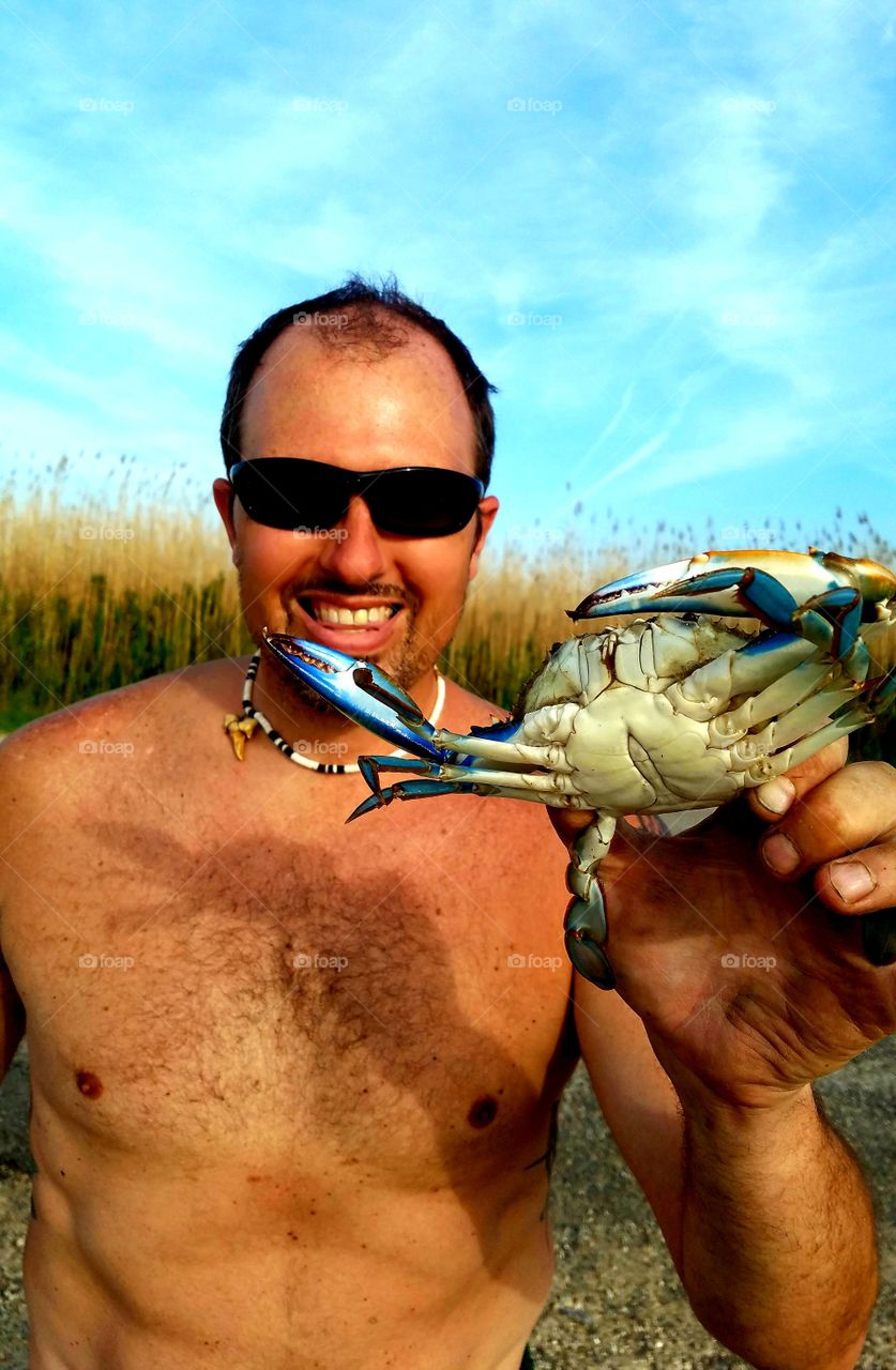 man holding a blue crab caught near Bridge City Texas United States of America 2018 off of the Gulf of Mexico.