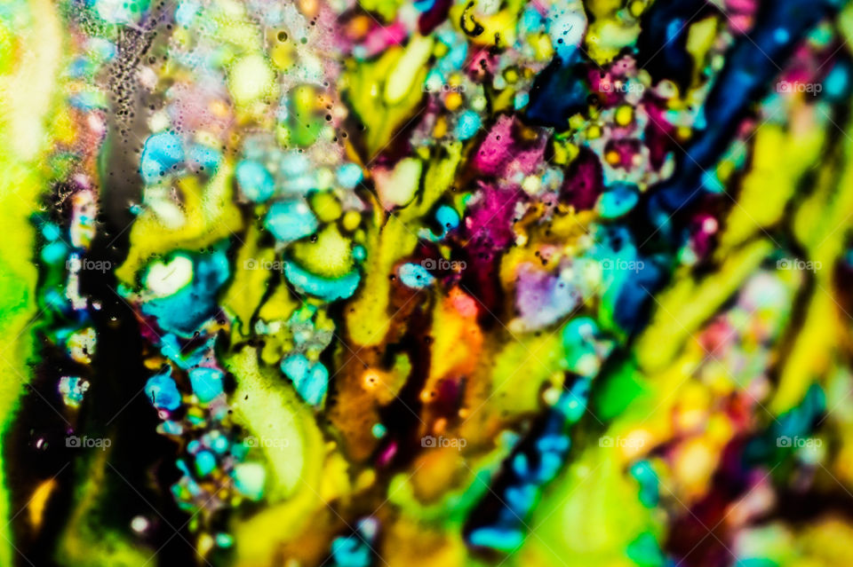 The ink to refill the printer cartridge was spilled onto the white washbasin and the paints blended into abstract drips and patterns.