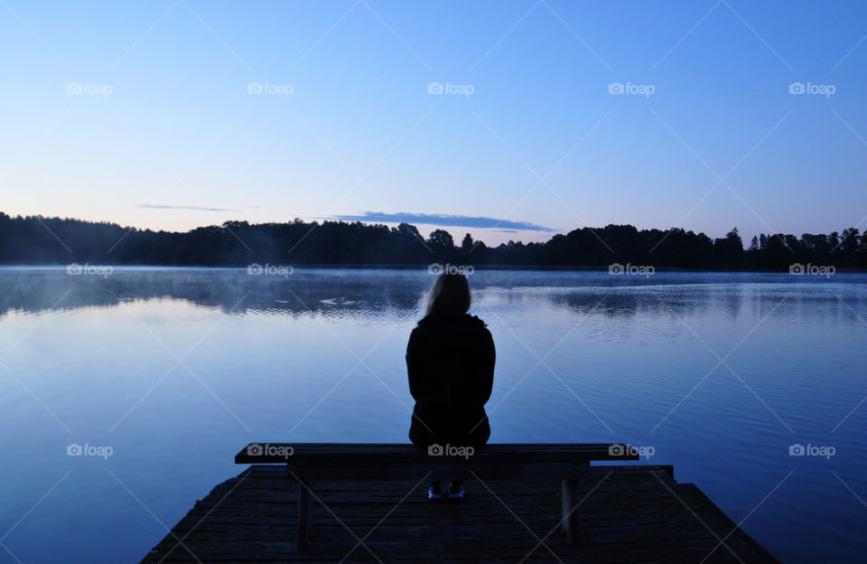 girl silhouette at the lakeside during sunrise