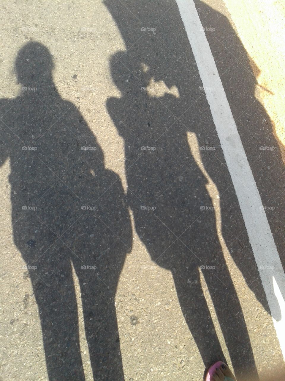 shadows of three girl walking through a road