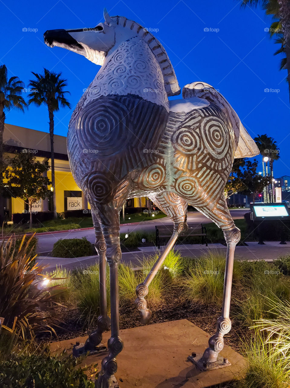 A whimsical horse statue proudly stands against a crystal blue backdrop