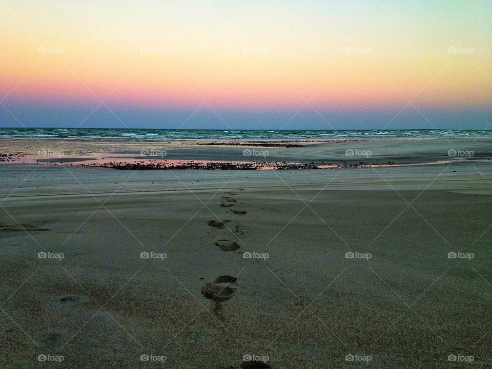 Foot steps on an empty beach
