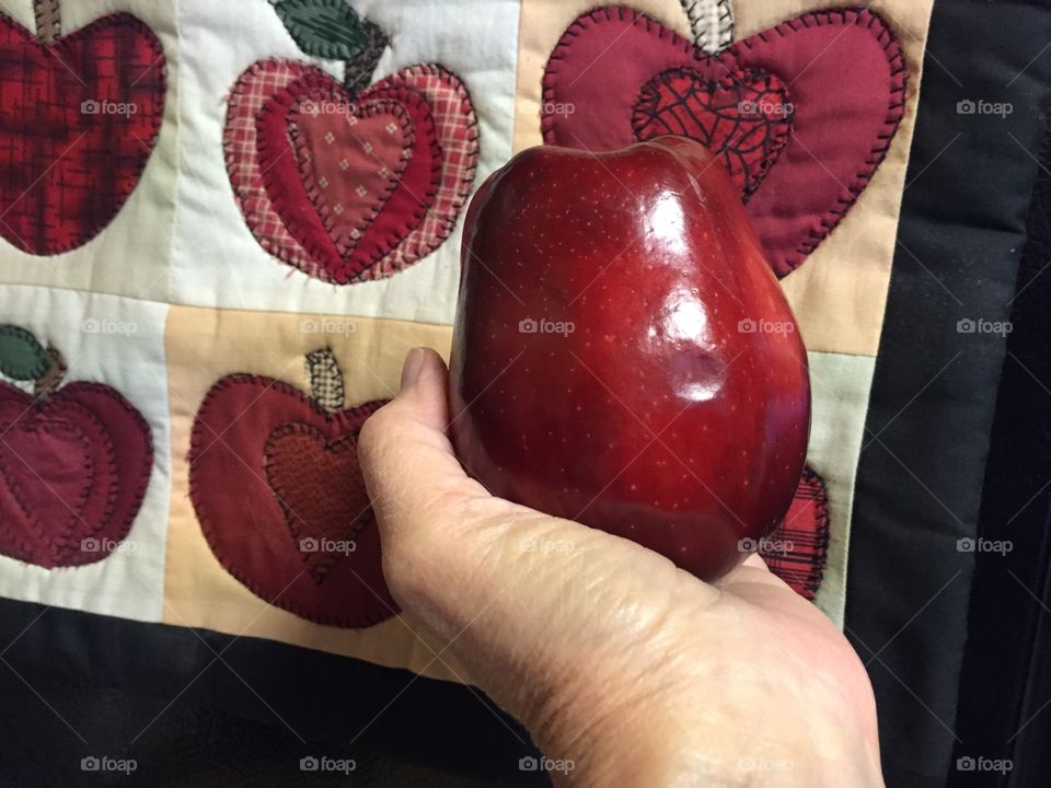 Person 's hand holding red apple