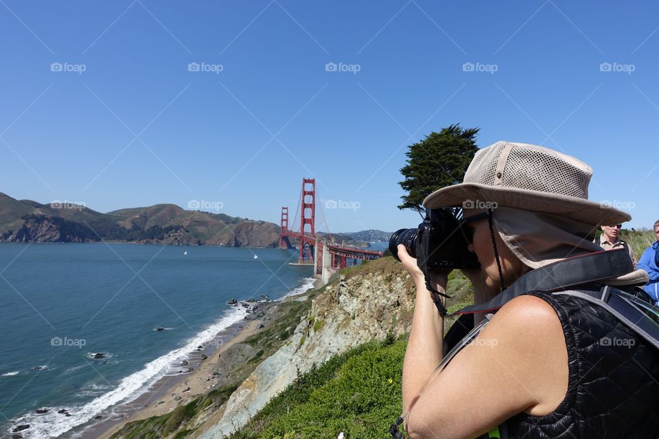 Woman photographer taking landscape shots near the Golden Gate Bridge in San Francisco, CA.