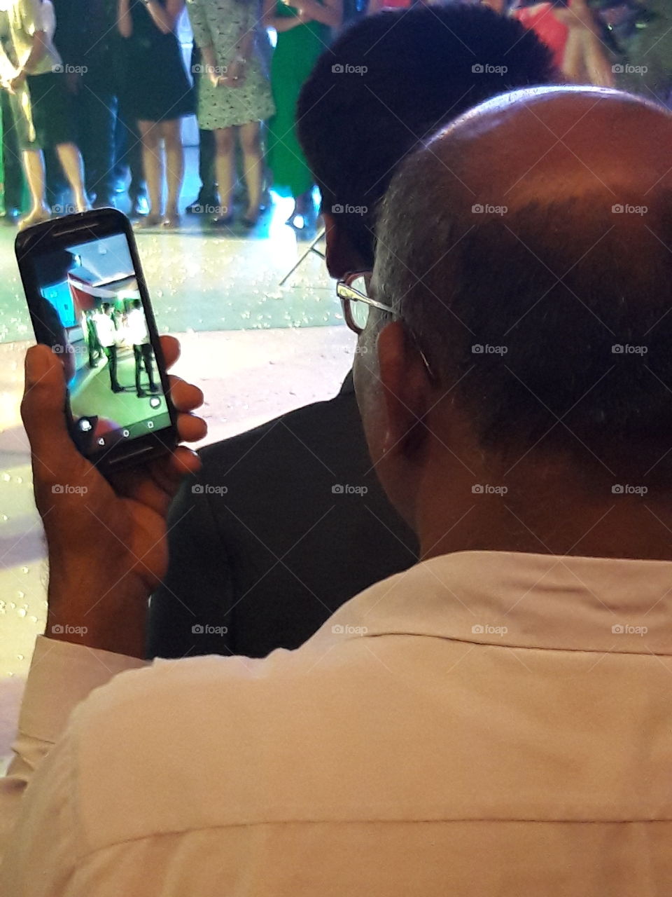 mobile camera fun videos recording of man taking video of people on his phone in party