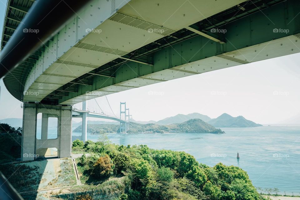 Reaching Bridge Over Water And Mountians