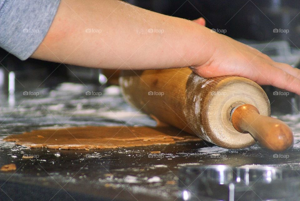Close-up of child's hand holding rolling pin