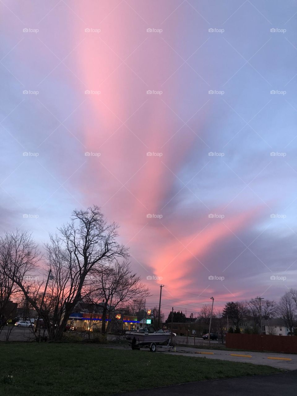 Giant clouds towering over silhouettes of tree tops in a small town