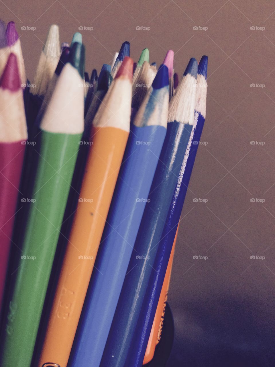 Jar of pencil crayons on a desk. 