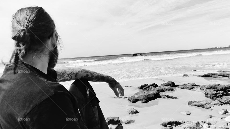 man sitting looking at the sea