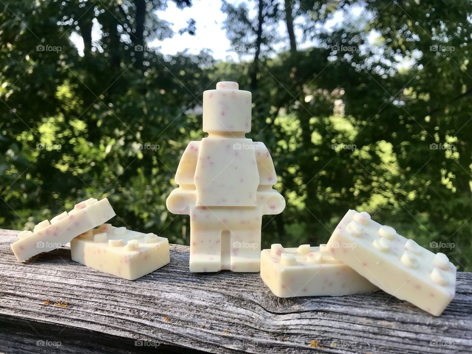 Fun photo of homemade white chocolate molds in rectangular block shapes sitting on wood deck. 