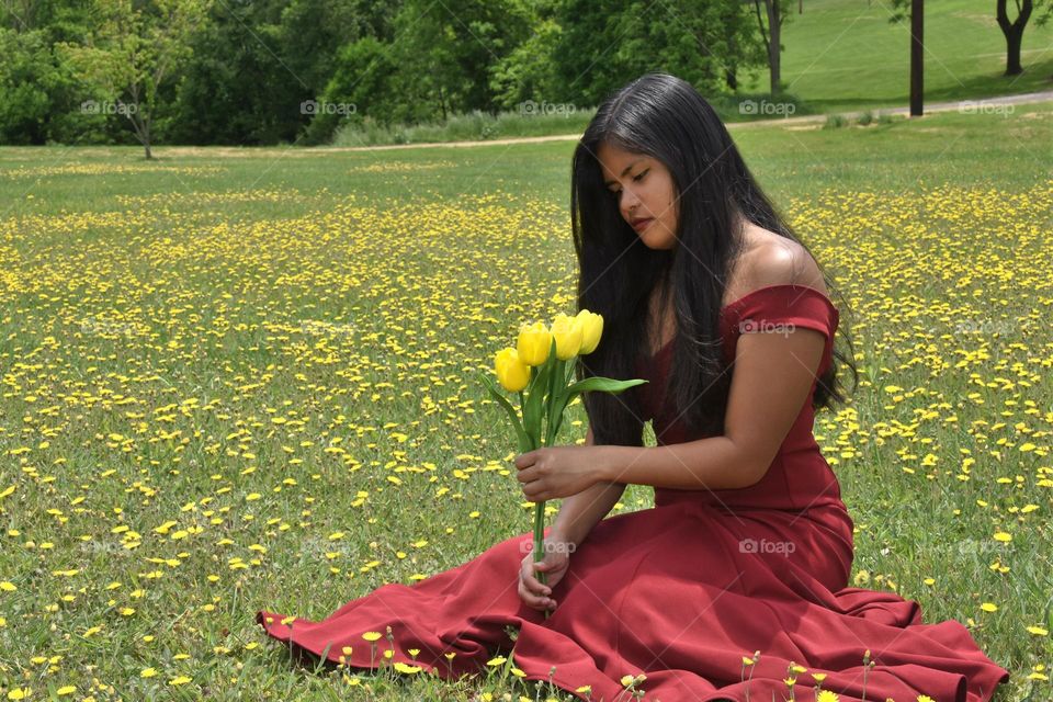 Teenage girl sitting in a field of flowers