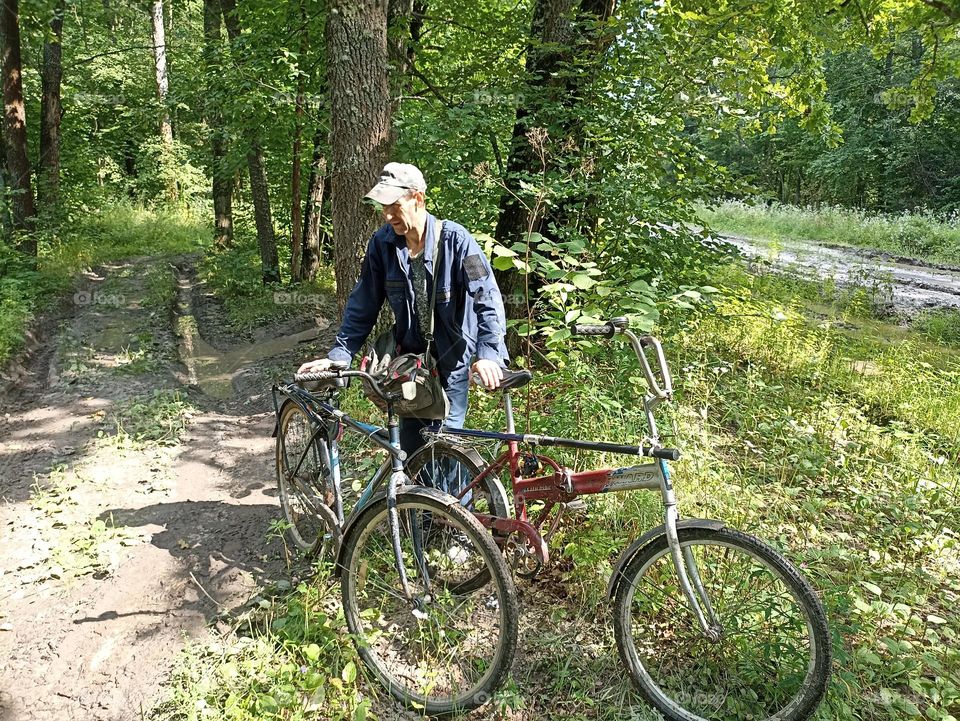 A man with a bicycle in the forest