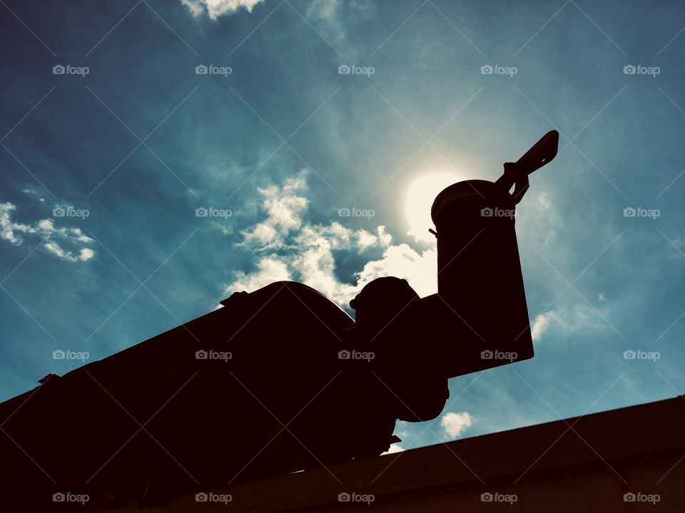 The sun behind a pipe on a generator in Florida 