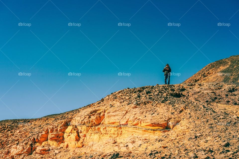Trekking to the top of hill at Black Desert in Egypt 