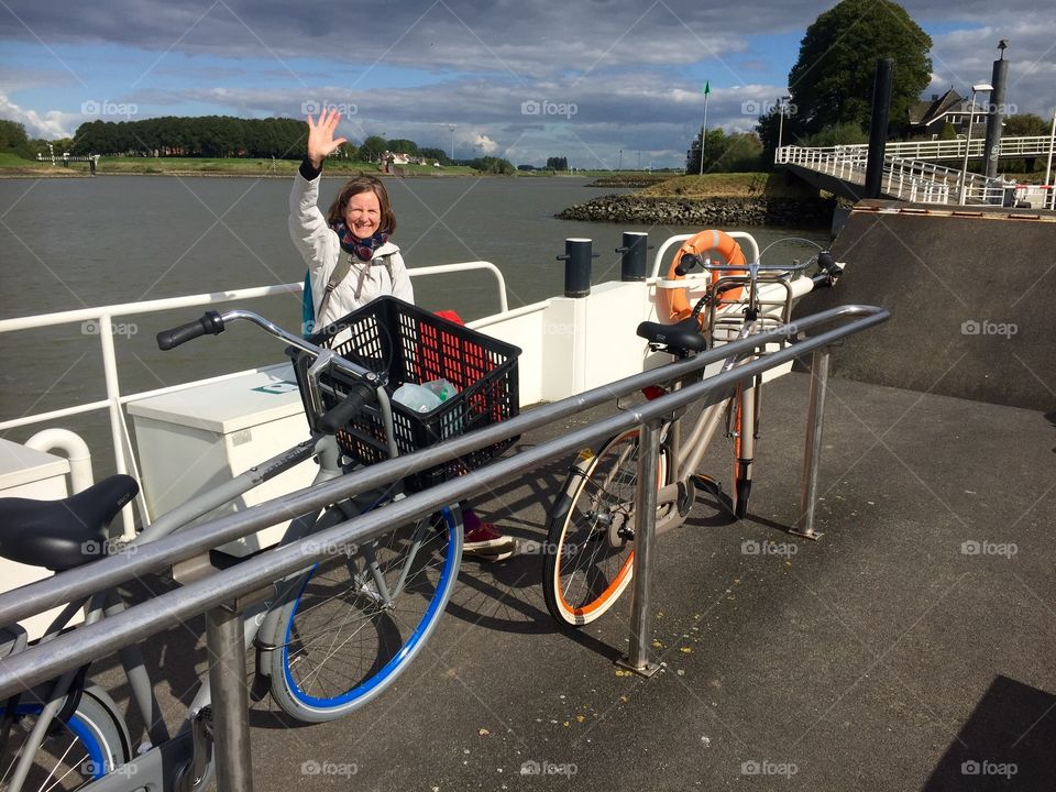 Mature woman saying hi standing near the bicycle rack