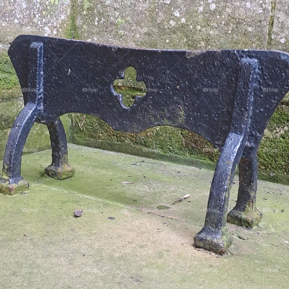 black metal ornate foot scraper, step, outside, green moss