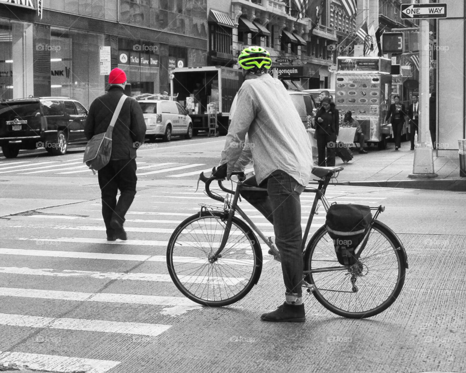 Black and White with Pops of Color Bicyclist and Pedestrian Crossing a Busy City Street