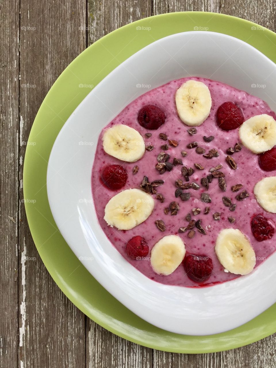 Fruit smoothie in white bowl on green plate