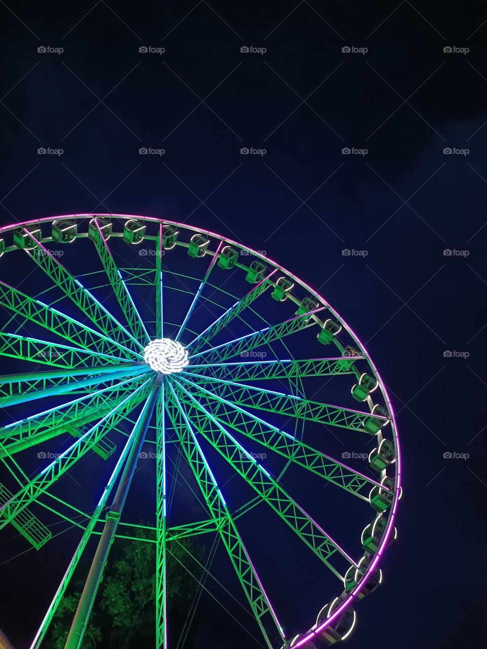 Close-up of a lightened big wheel in front of a dark sky
