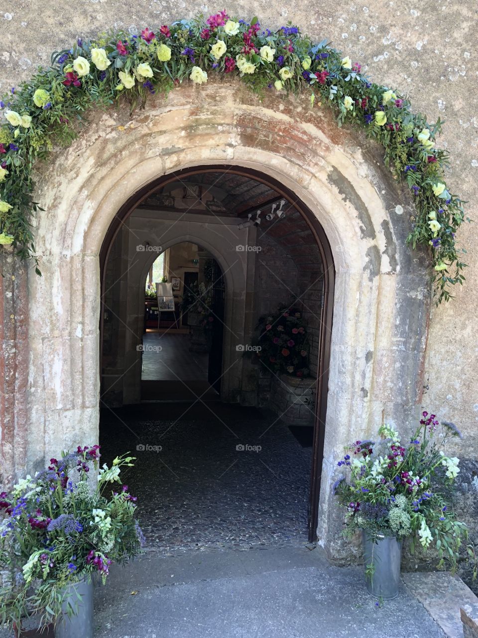 Entrance to Kingswerswell church in Devon, nicely decorated with summer blooms to match blooming lovely sunny weather.
