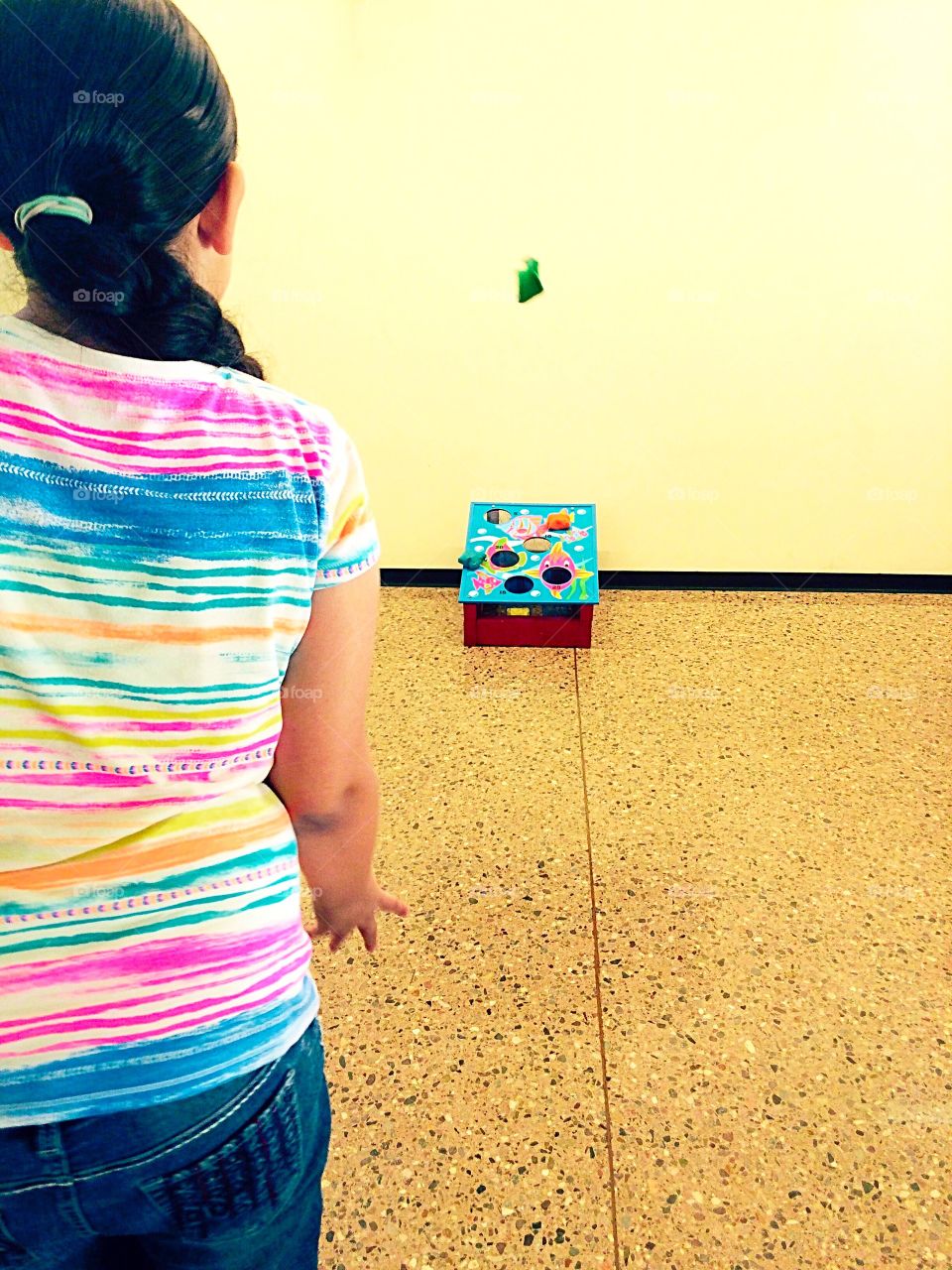 Girl playing cornhole 