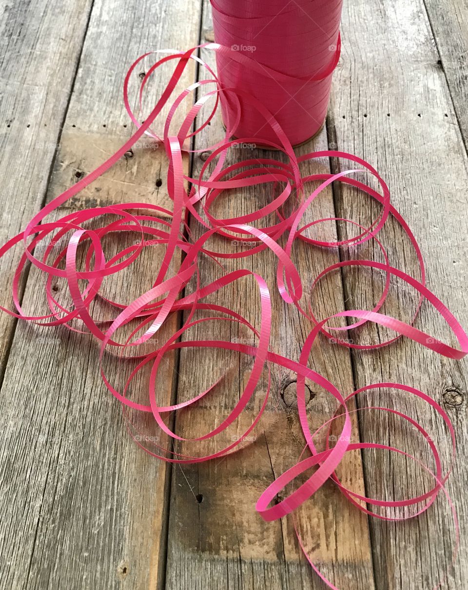 Pink ribbon on wooden table