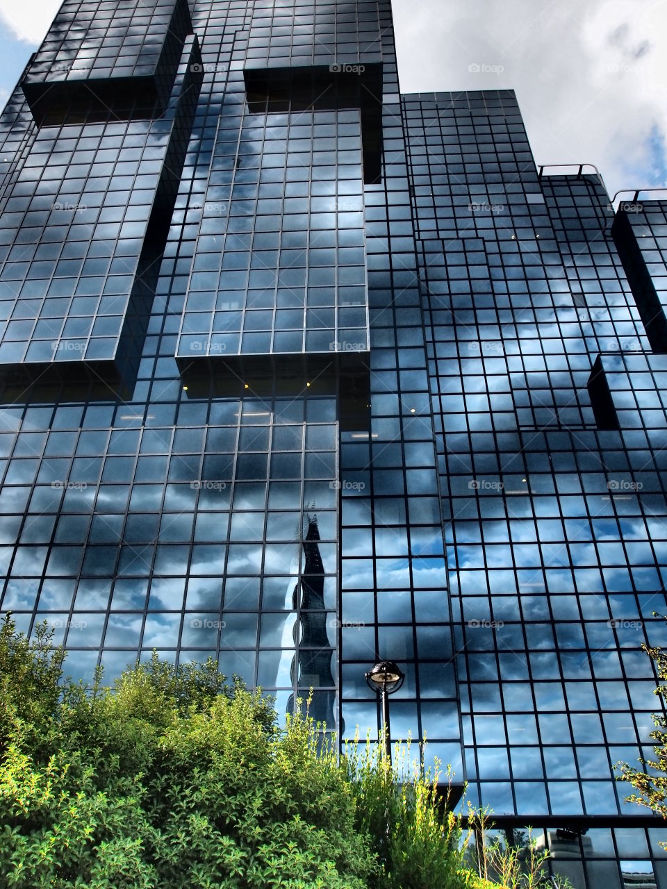 Amazing modules on a glass building reflecting the clouds in the sky in London exhibiting creative modern architecture. 