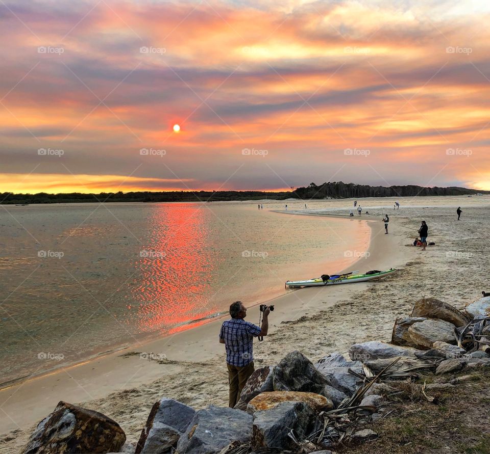 The photographer at the beach at sunset 