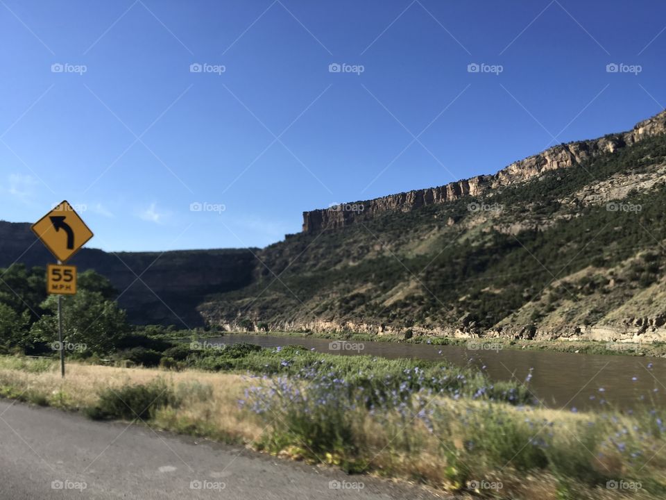 A Colorado morning, in early July. Beautiful blue sky, water rushing down the mountains, and green along the Highway. 
