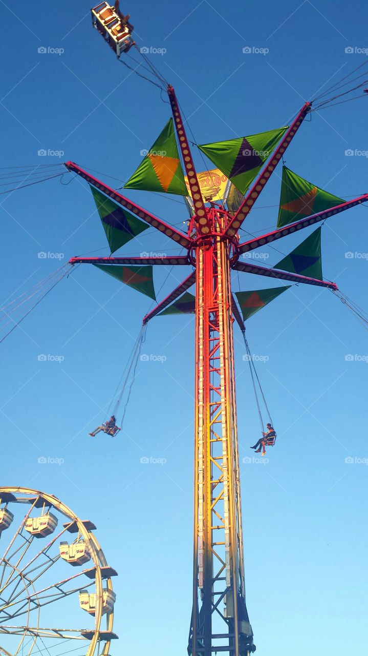 vertigo swing ride with ferris wheel at the back, fairgrounds