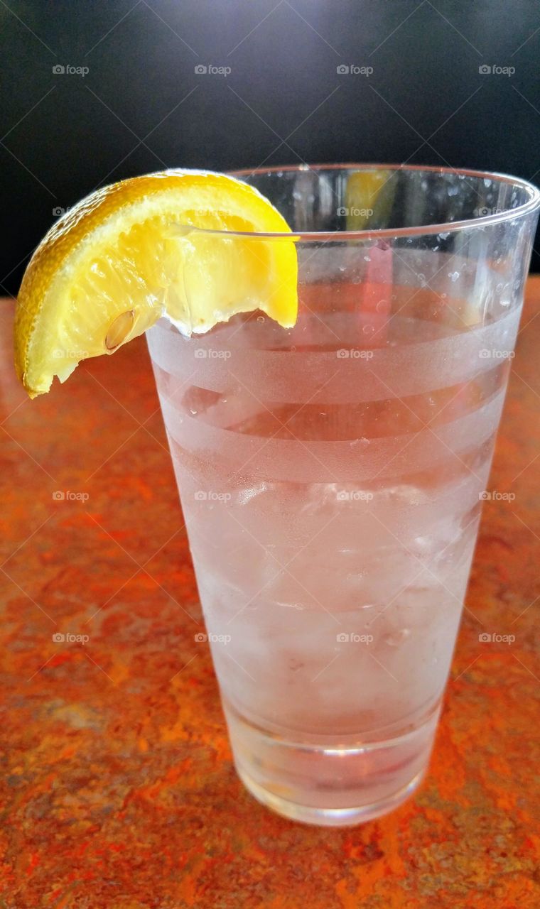 glass of ice water with lemon wedge