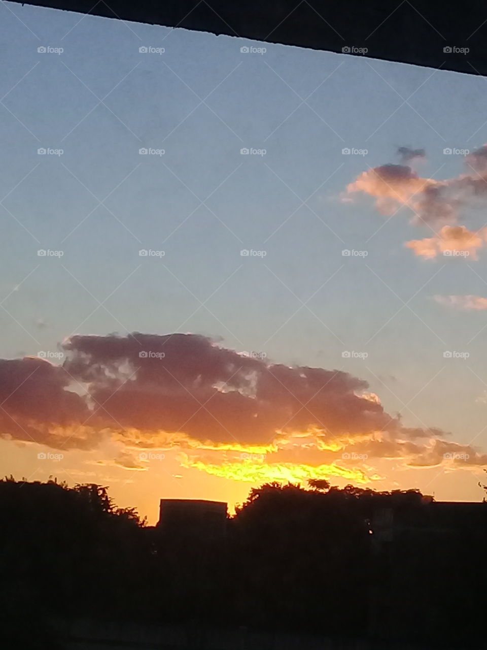 vista de una puesta de sol en una zona urbana de la ciudad de Buenos Aires, tomada desde un vehículo a cierta distancia