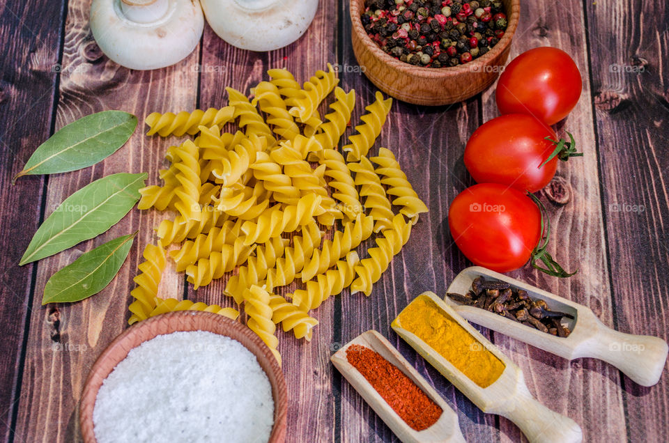 Raw pasta with ingredients and wooden accessories